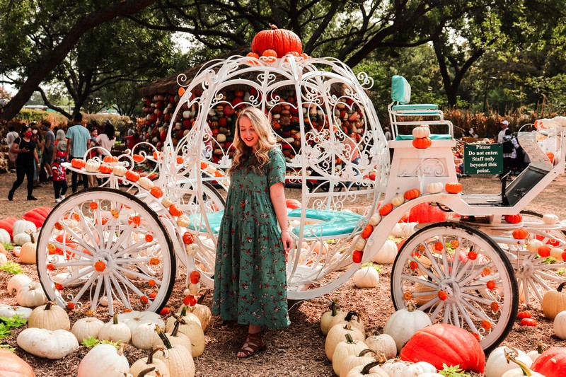 Julie Wells in front of the pumpkin carriage at the Dallas Arboretum